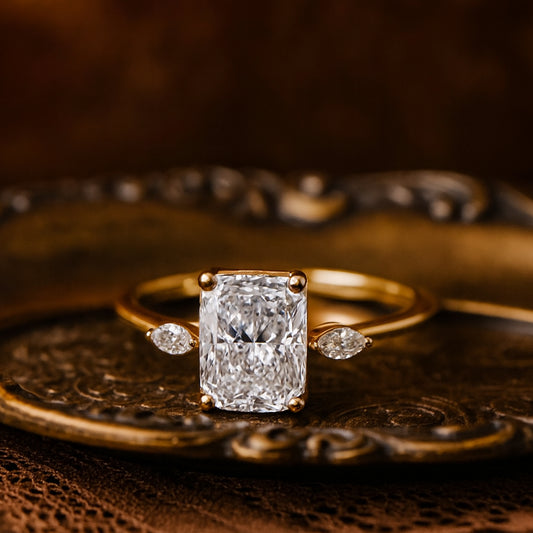 Romantic Cushion-Cut Diamond Ring With Pear Side Stones Set In Yellow Gold, Captured In Warm Vintage Lighting For Timeless Elegance