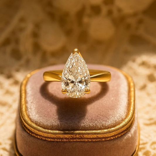 Elegant Pear Cut Moissanite Engagement Ring In Gold Setting With Diamond-Like Sparkle And Timeless Classic Style.