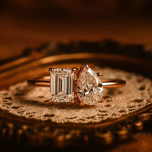 Elegant Toi Et Moi Ring Featuring 2 CT Emerald And Pear Shape Moissanite Stones Set In Rose Gold, A Brilliant Diamond Alternative.