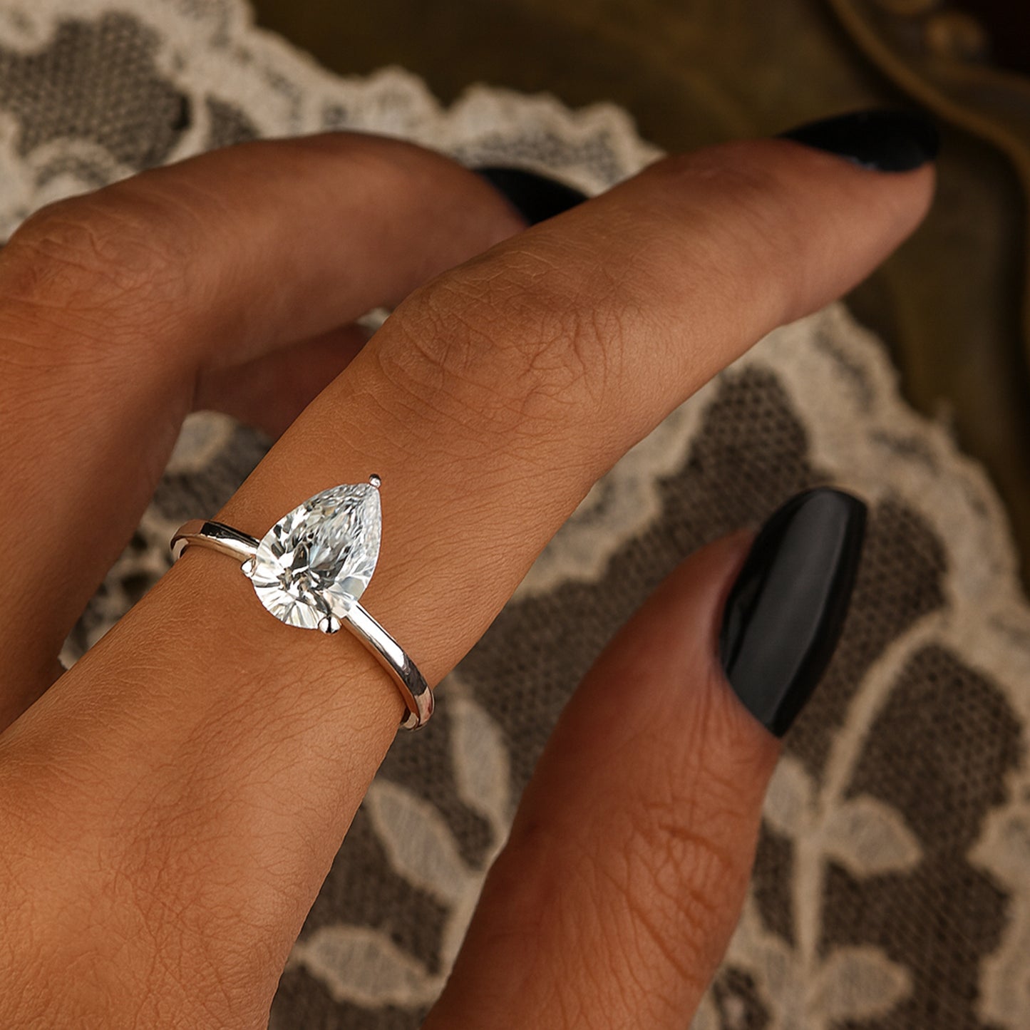 Lustrous White Gold Solitaire Ring Showcasing Sparkling Pear Shaped Moissanite Gemstone.