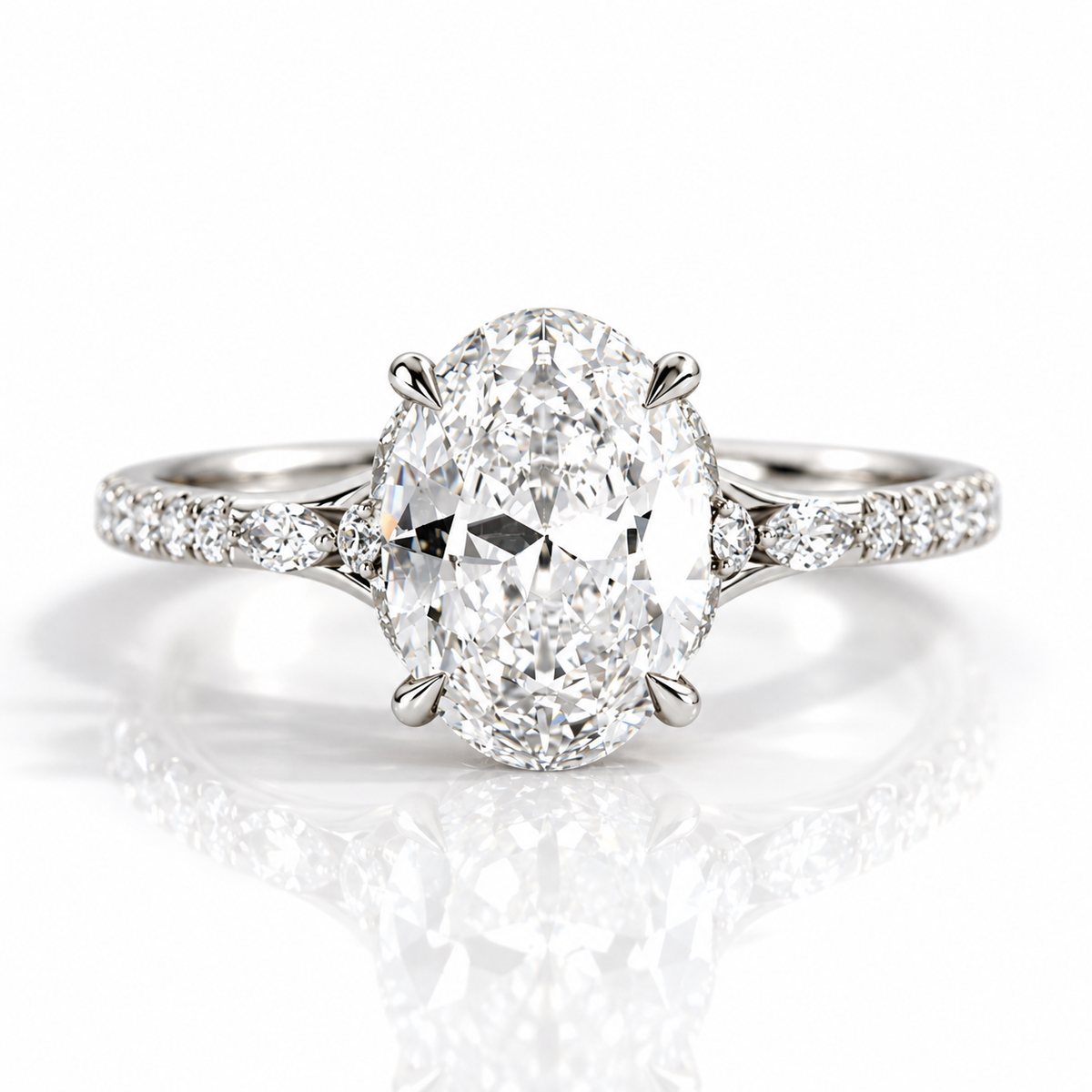 Silver oval-cut engagement ring with pavé diamond band and four-prong setting on a white background.