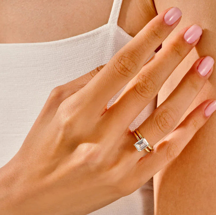 Emerald cut solitaire ring with diamond band
