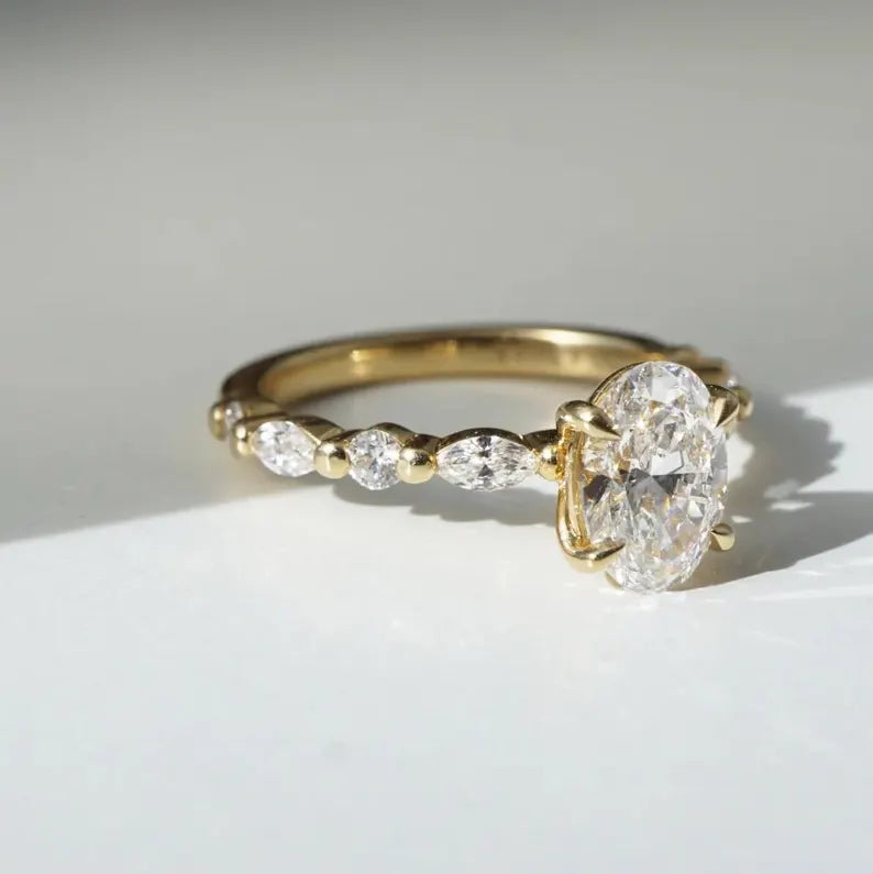 Yellow Gold Oval Engagement Ring With Marquise And Round Side Stones
