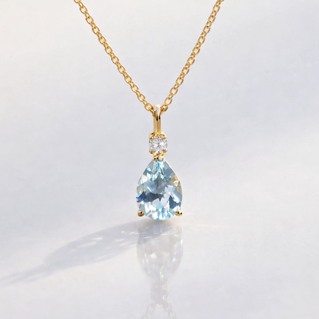 Aquamarine Pear-Shaped Pendant With Round Diamond Accent In Yellow Gold.
