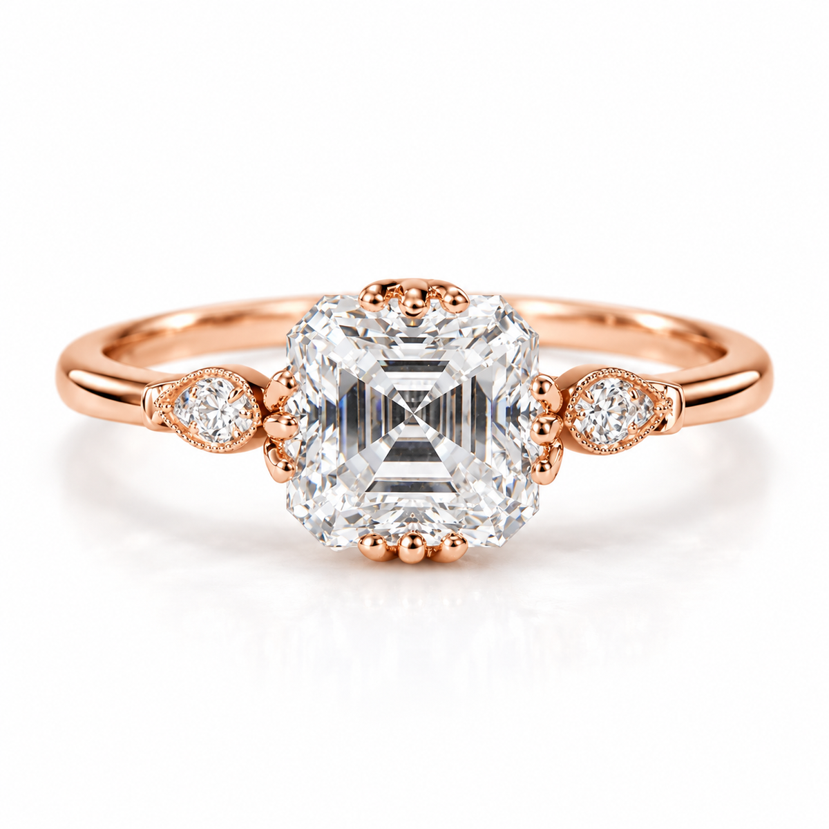 18K rose gold vermeil Asscher cut engagement ring with a large step cut center stone, pear shaped diamond side accents, and delicate milgrain detailing on a slim polished band.