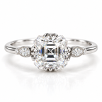 Polished silver Asscher cut engagement ring with a large step cut center stone, pear shaped diamond side accents, and delicate milgrain detailing on a slim band.