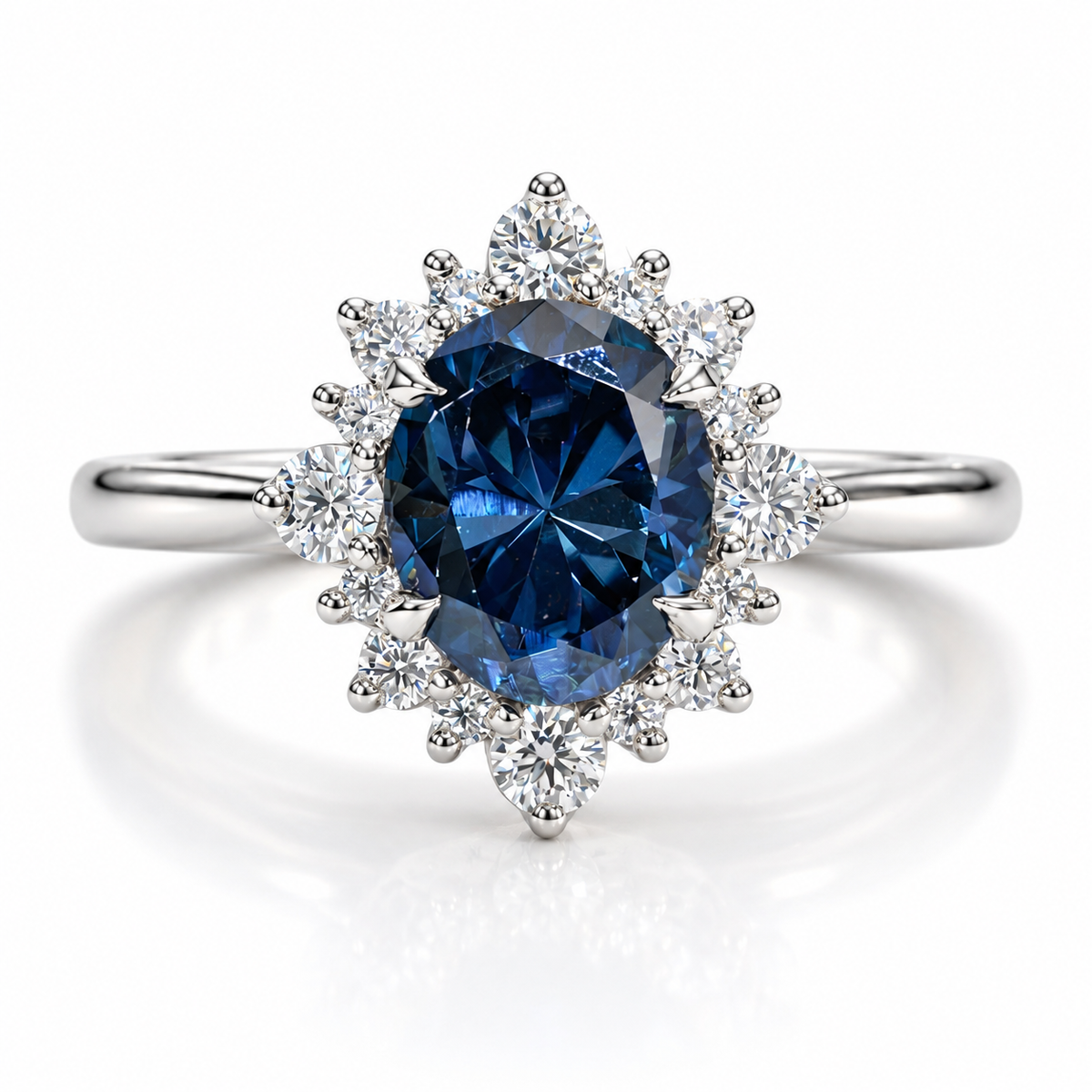 Round blue sapphire halo engagement ring with silver band, featuring a deep blue center gemstone surrounded by sparkling diamond accents in a floral cluster setting.