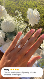 Hand with a natural pink manicure wearing a rose gold marquise diamond solitaire engagement ring stacked with a slim pavé diamond wedding band, held up in front of white roses and baby’s breath in warm sunlight, with a four-star customer review from Mary overlaid at the bottom