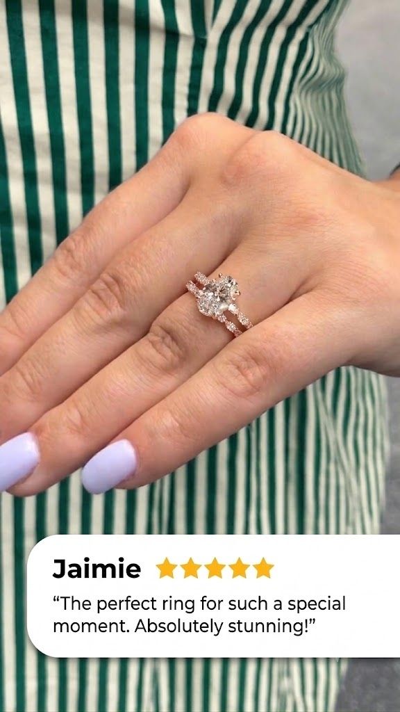 Hand with lavender nails wearing a rose gold oval diamond engagement ring stacked with a matching wedding band of marquise and round diamonds, shown against a green and white striped apron, with a five-star customer review from Jaimie overlaid at the bottom