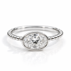 Polished silver oval gemstone ring with a bezel setting and beaded band