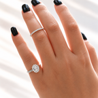 Oval cut colorless ring stone with an elongated shape and bright faceted sparkle, framed by a halo of small round stones