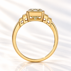 Side profile of an emerald cut diamond in a yellow gold bezel setting with stepped baguette side stones and an open gallery