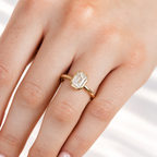 Emerald cut diamond center stone in a yellow gold bezel setting on a slim polished band