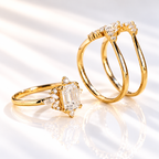 Emerald cut colorless ring stone with a clear table and sharp step cut facets, flanked by small marquise accent stones