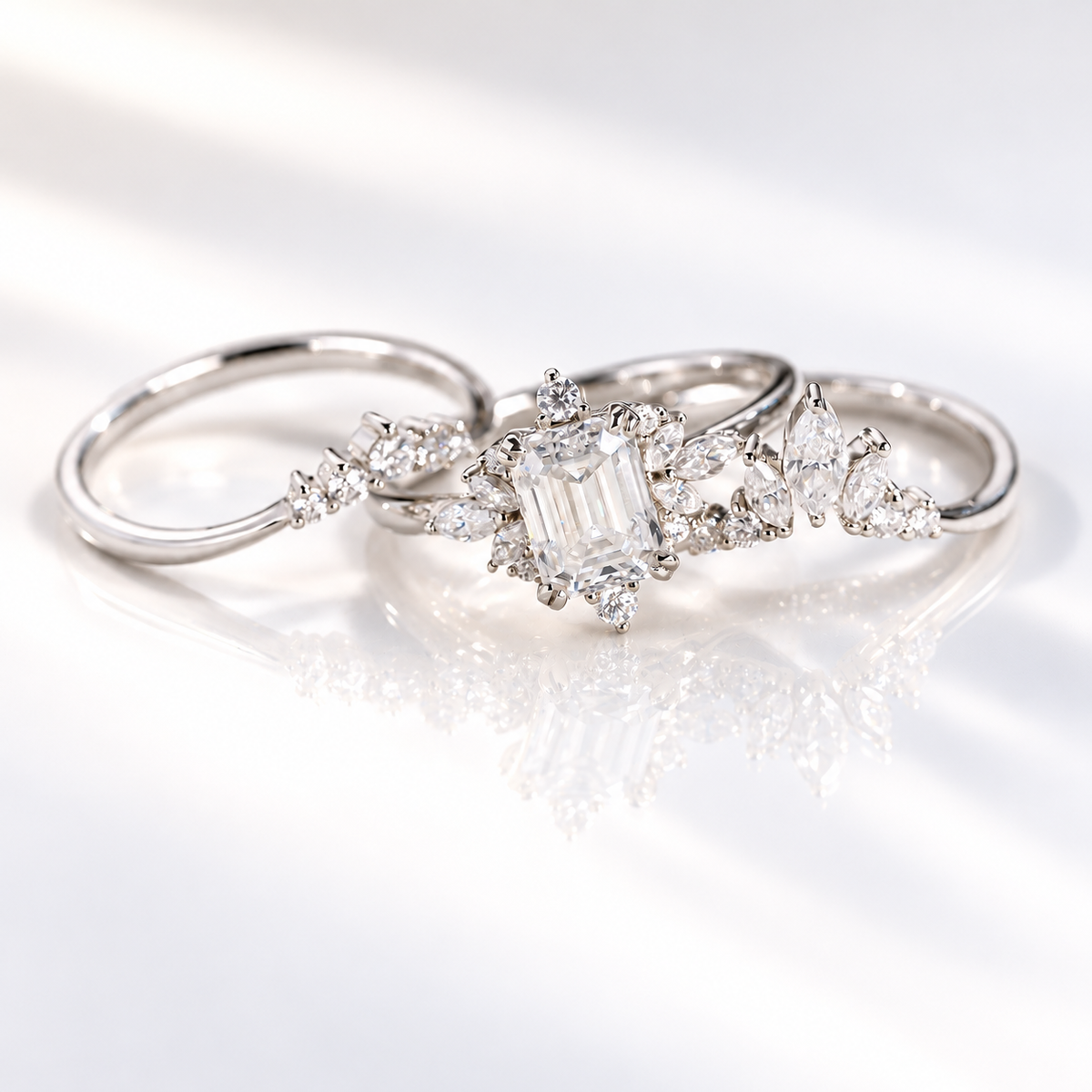 Emerald cut clear ring stone with a clean rectangular shape and bright step cut facets, surrounded by small accent stones
