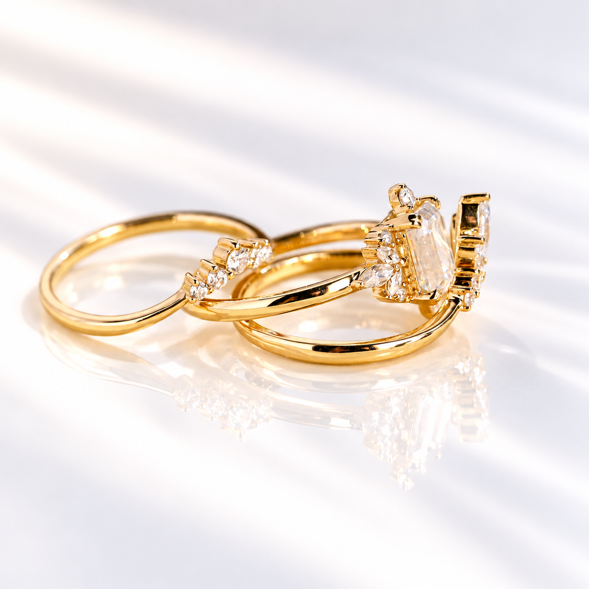 Profile of an emerald cut colorless ring stone showing its stone depth and clear step cut facets, with small accent stones beside it