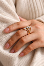 Emerald cut colorless ring stone with an elongated rectangular shape and soft sparkle, surrounded by small marquise and round accent stones