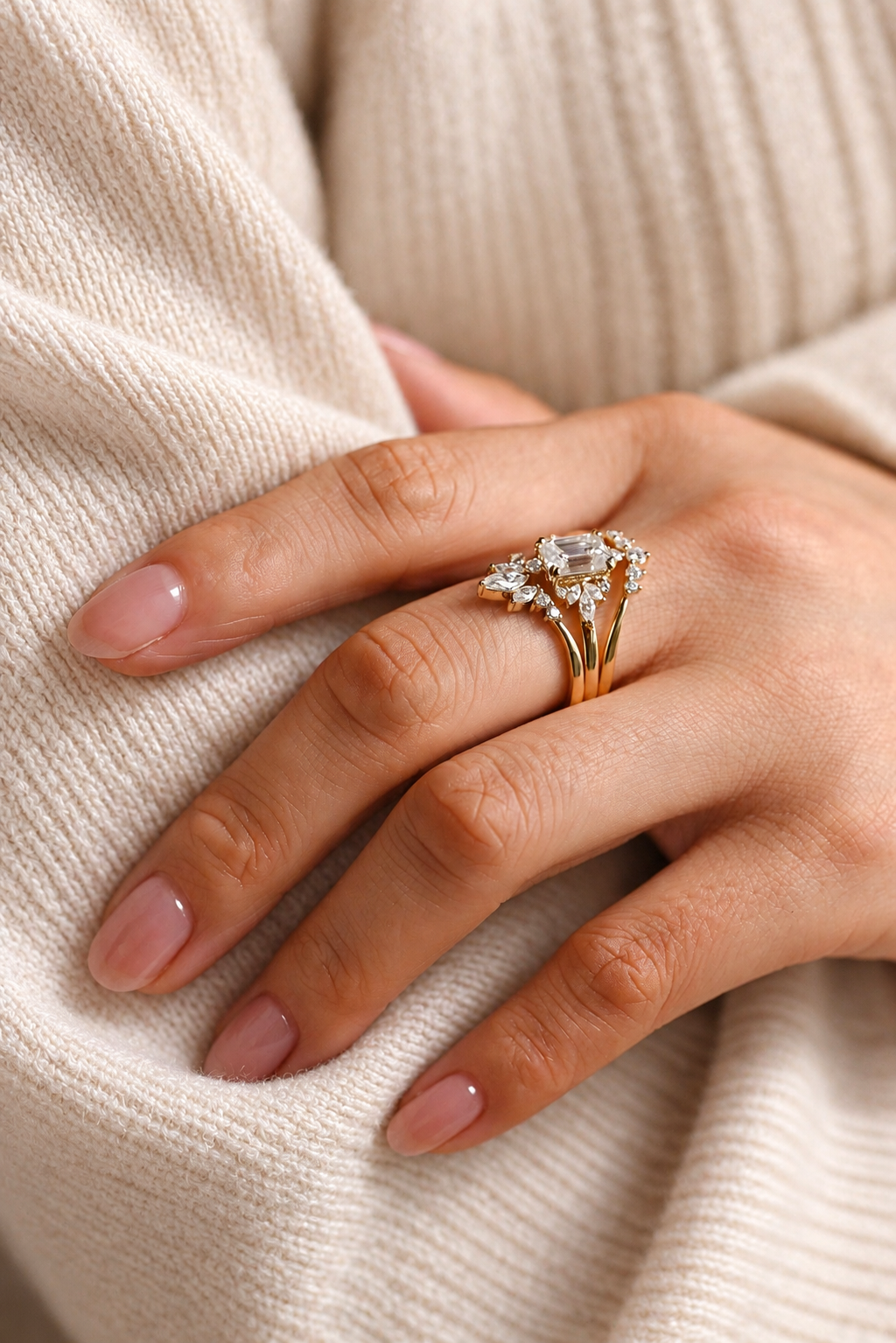 Emerald cut colorless ring stone with an elongated rectangular shape and soft sparkle, surrounded by small marquise and round accent stones