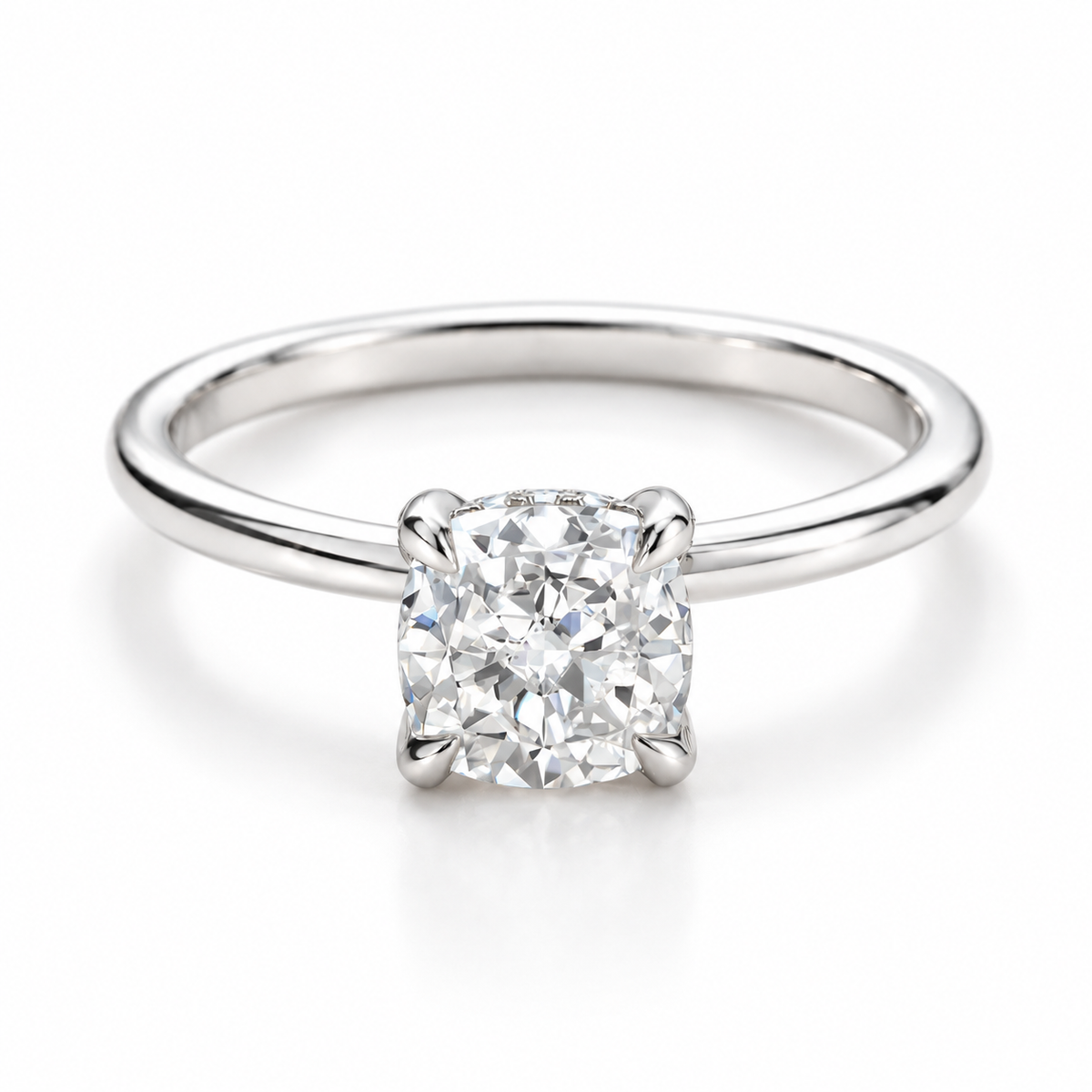 Polished silver solitaire engagement ring featuring a cushion-cut diamond with a four-prong setting, sleek silver band, brilliant gemstone sparkle, and elegant minimalist fine jewelry design on a clean white background.