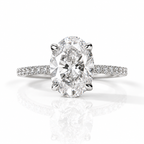 Silver oval-cut diamond engagement ring with pavé diamond band on a white background.