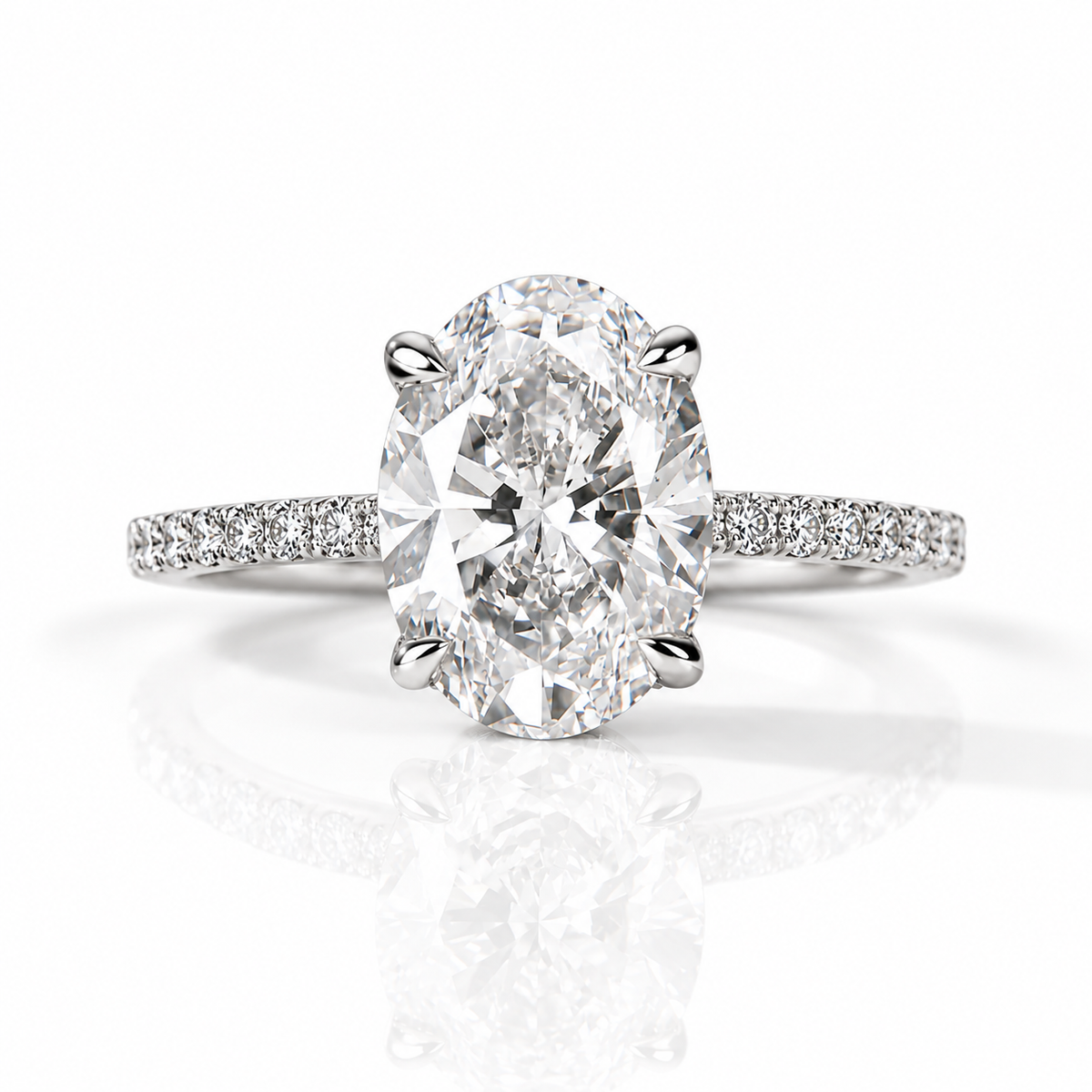 Silver oval-cut diamond engagement ring with pavé diamond band on a white background.
