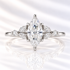 Marquise cut diamond center stone in a six-prong white gold setting, flanked by two marquise and one round side stones on each side