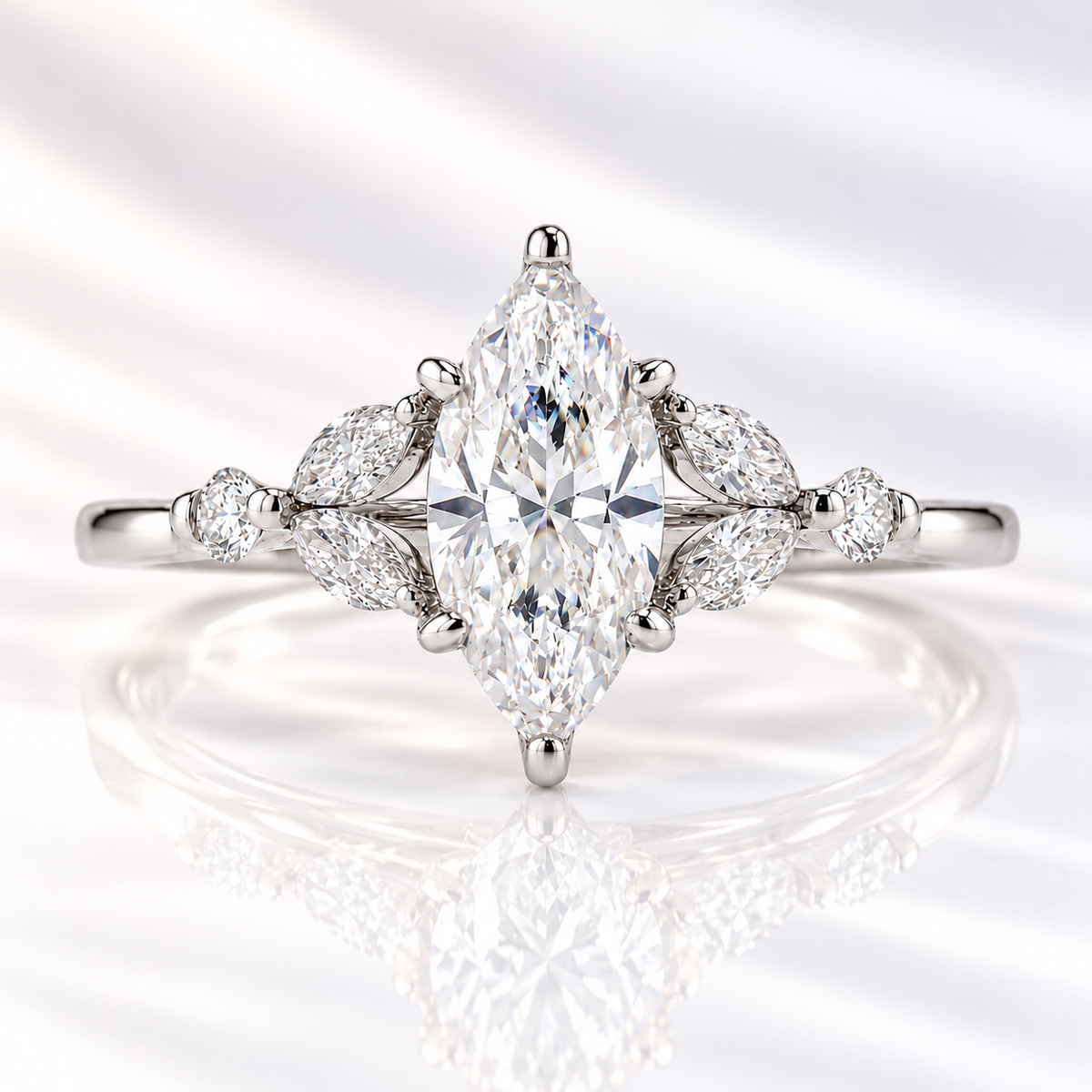 Marquise cut diamond center stone in a six-prong white gold setting, flanked by two marquise and one round side stones on each side