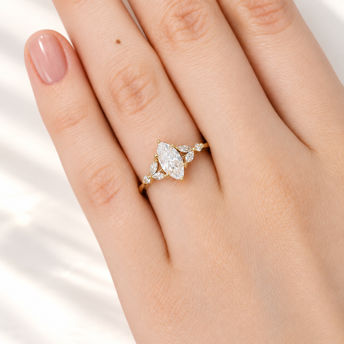 Marquise cut diamond center stone with marquise and round side stones in a yellow gold prong setting