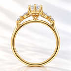Side profile of a marquise cut diamond in a raised yellow gold prong setting with a gallery of marquise and round side stones