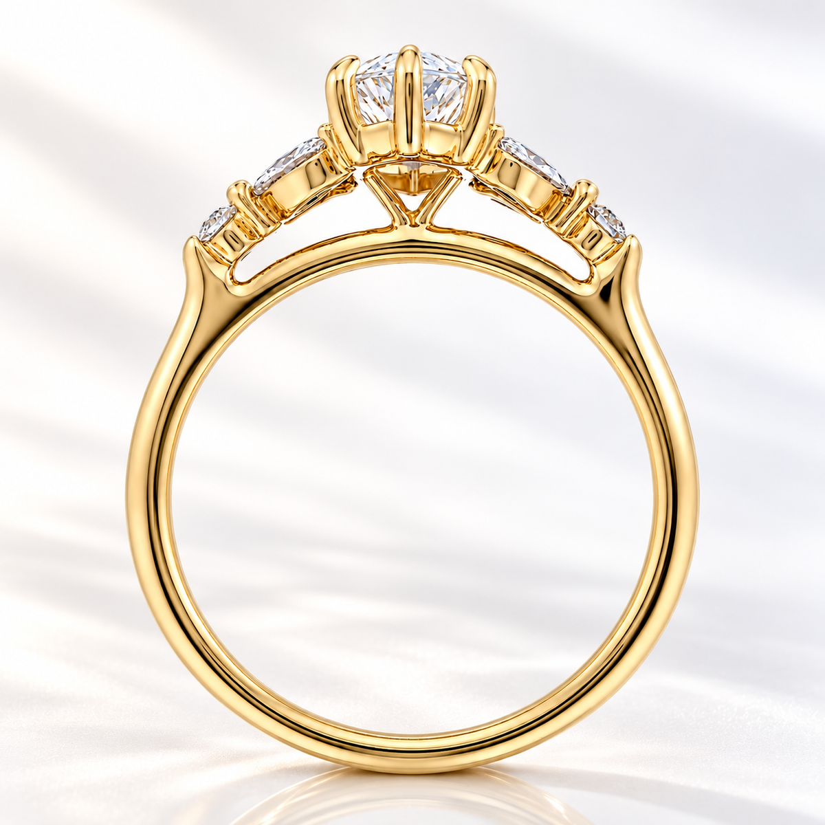 Side profile of a marquise cut diamond in a raised yellow gold prong setting with a gallery of marquise and round side stones