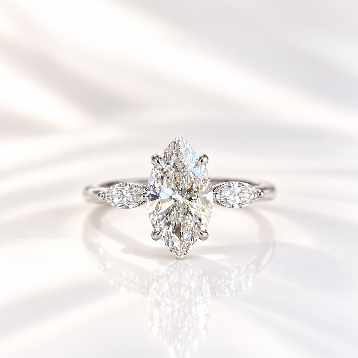Marquise cut diamond center stone in a four-prong white gold setting, flanked by a marquise cut side stone on each side