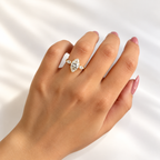 Marquise cut diamond center stone in a four-prong yellow gold setting with a marquise cut side stone on each side