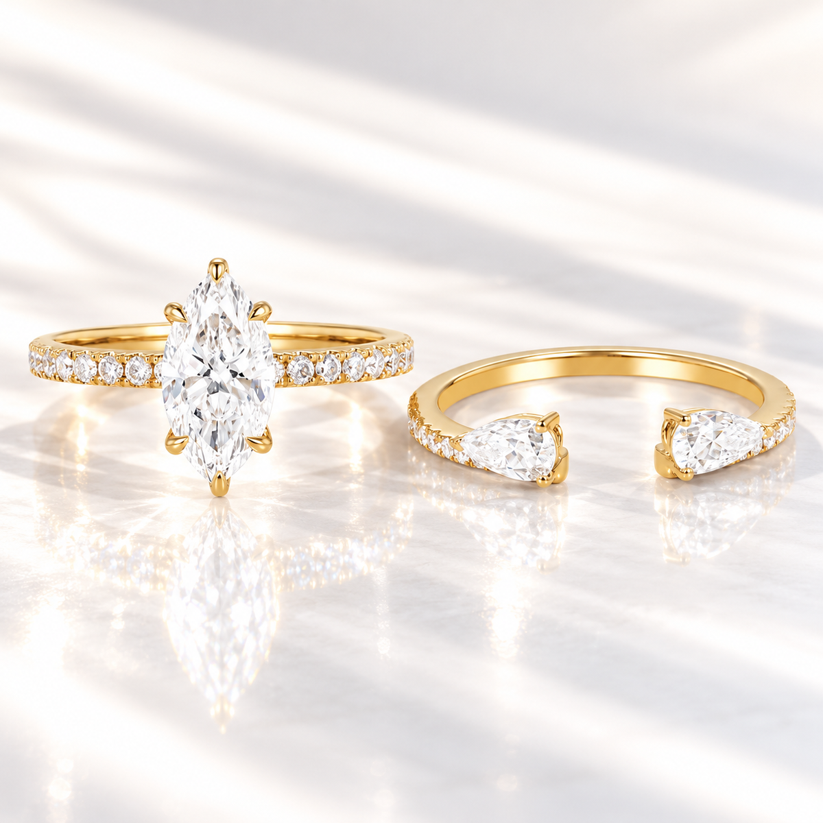 Marquise cut colorless ring stone with a clear table, bright facets, and symmetrical pointed ends, beside a pear cut ring stone