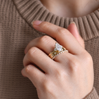 Marquise cut colorless ring stone with sharp brilliant facets and soft white sparkle, held by prongs with small accent stones
