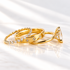 Side angle of a marquise cut ring stone showing its depth and brilliant facets, with small round accent stones beside it