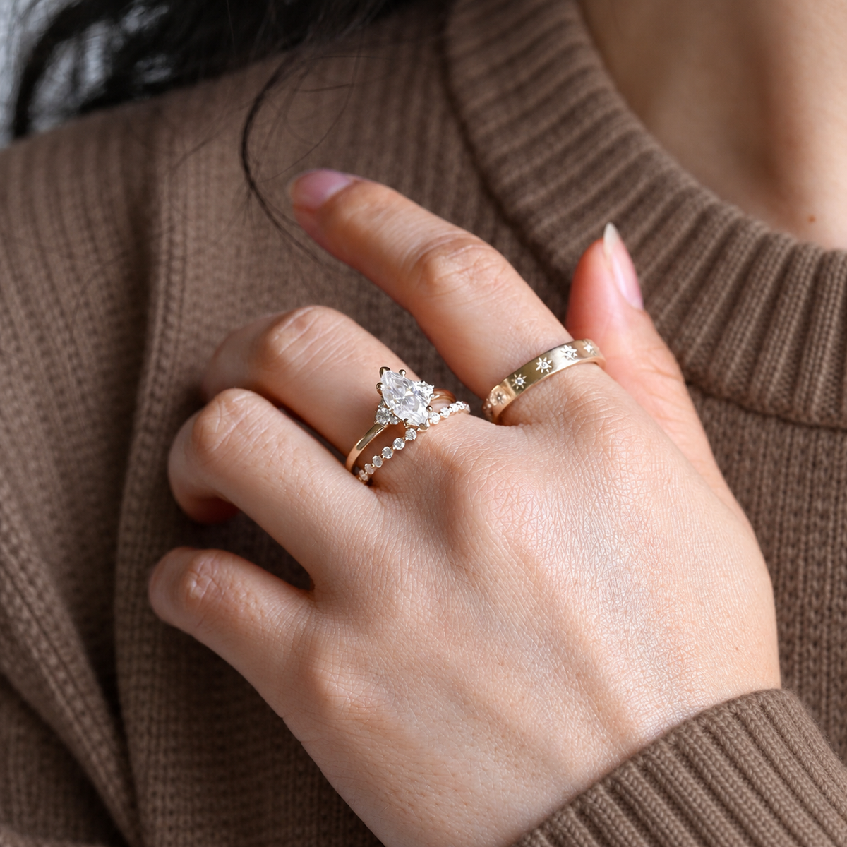 Marquise cut colorless ring stone with an elongated shape and bright faceted sparkle, set with small round accent stones