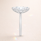 Diamond ring with a Marquise center stone on a light beige background