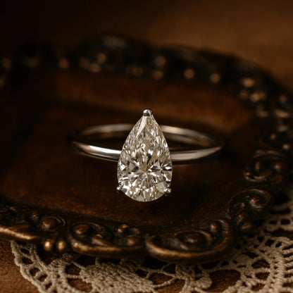 Classic 10K White Gold Solitaire Ring Featuring Brilliant Pear Cut Moissanite Stone.