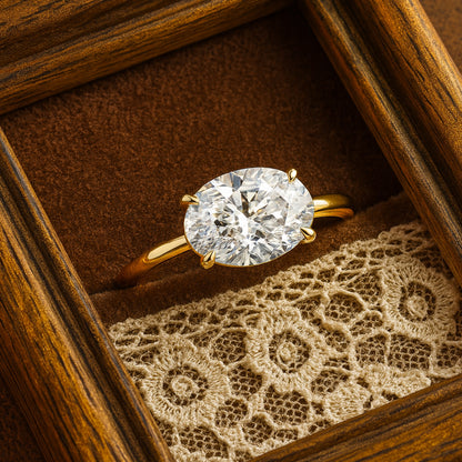 Oval Diamond Solitaire Engagement Ring In Yellow Gold On Vintage Lace Background.