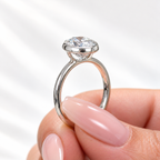 Side profile of an oval cut diamond in a white gold bezel setting with an open gallery and slim polished band