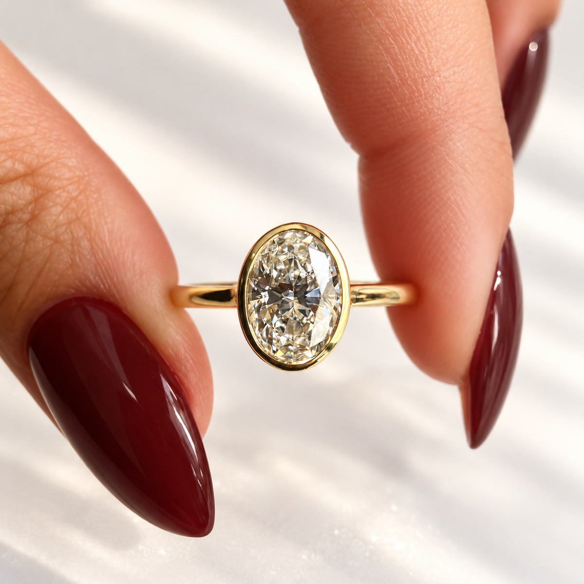 Close-up of an oval cut diamond center stone in a yellow gold bezel setting