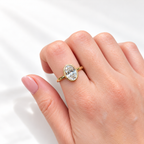 Oval cut diamond center stone in a yellow gold bezel setting on a slim polished band