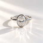 Oval cut diamond center stone in a white gold bezel setting