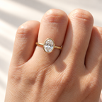 Oval cut diamond center stone in a yellow gold bezel setting