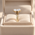 Side profile of an oval cut diamond in a yellow gold bezel setting on a slim polished band