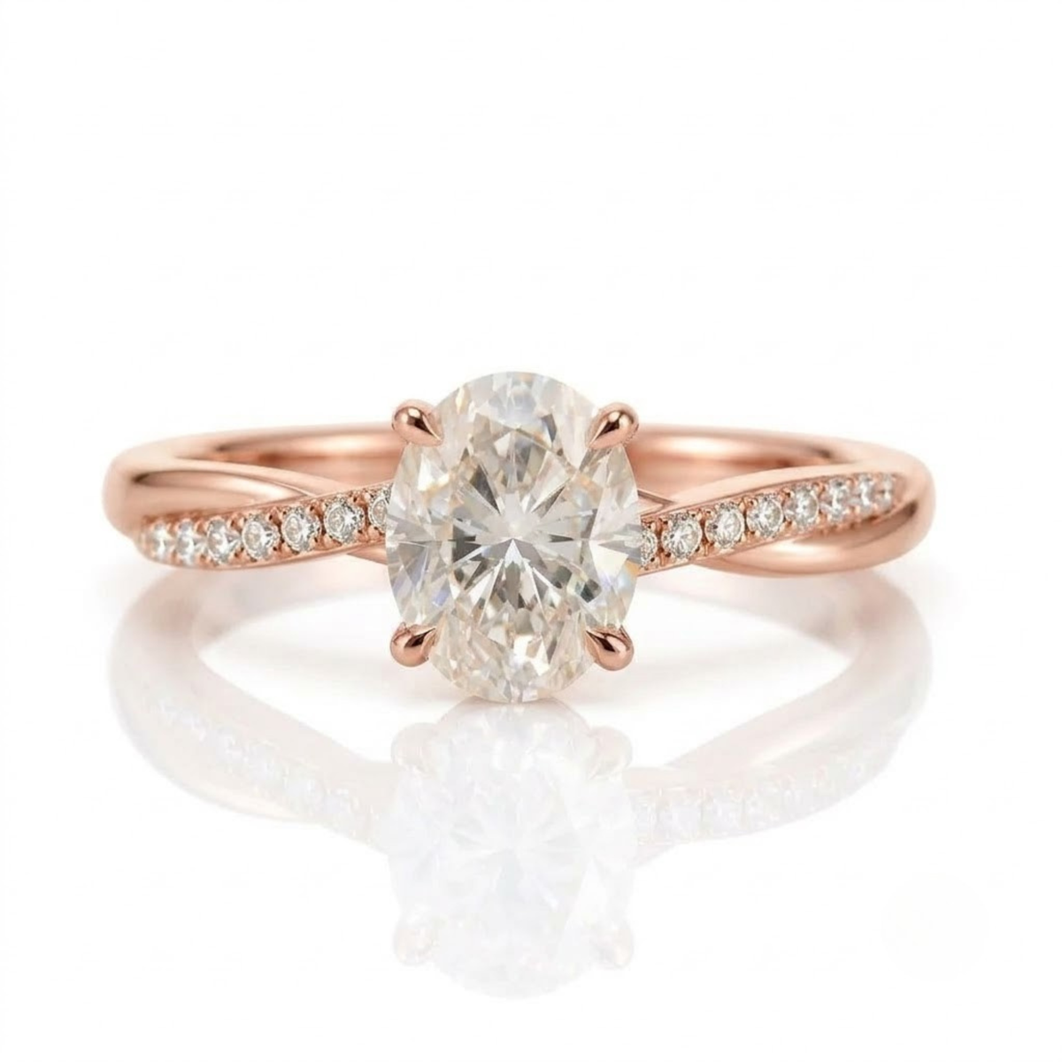 A high-quality, close-up product photograph of a delicate rose gold engagement ring, featuring a central oval-cut solitaire diamond held by four prongs, on a white reflective surface with soft lighting.