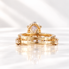 Back view of an oval cut ring stone showing its pavilion facets, prongs, and a hidden halo of small stones beneath
