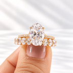 Close up of an oval cut colorless ring stone with clear brilliant facets, bright sparkle, and four prongs