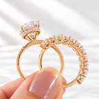 Oval cut colorless ring stone with brilliant facets, four prongs, and a hidden halo of small round stones beneath