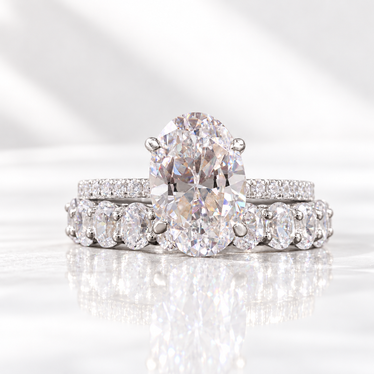 Oval cut clear ring stone with sharp brilliant facets and soft rainbow flashes in a four-prong setting